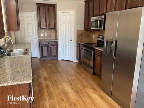 A kitchen with wooden cabinets and a stainless steel refrigerator.