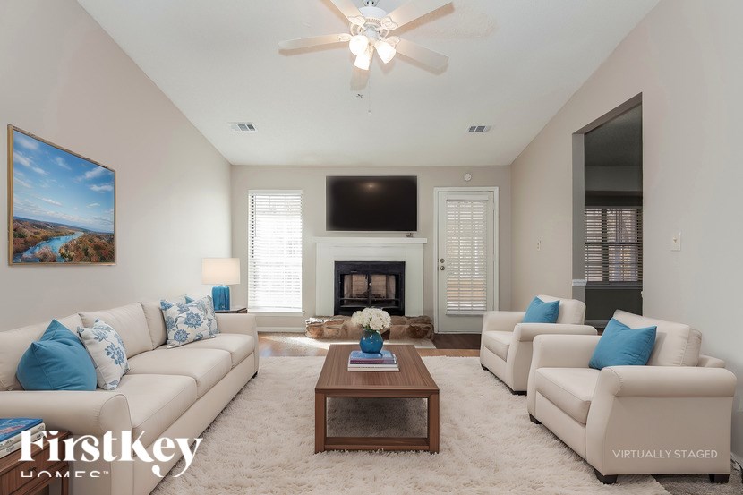 A living room with a fireplace, a television, and a painting on the wall.