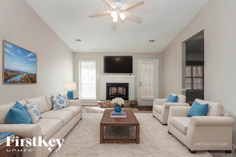 A living room with a fireplace, a television, and a painting on the wall.