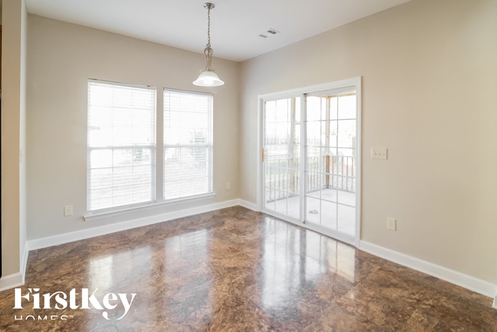 A large empty room with a marble floor and a hanging light fixture.
