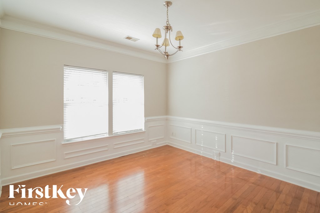 A room with wooden floors and a chandelier.