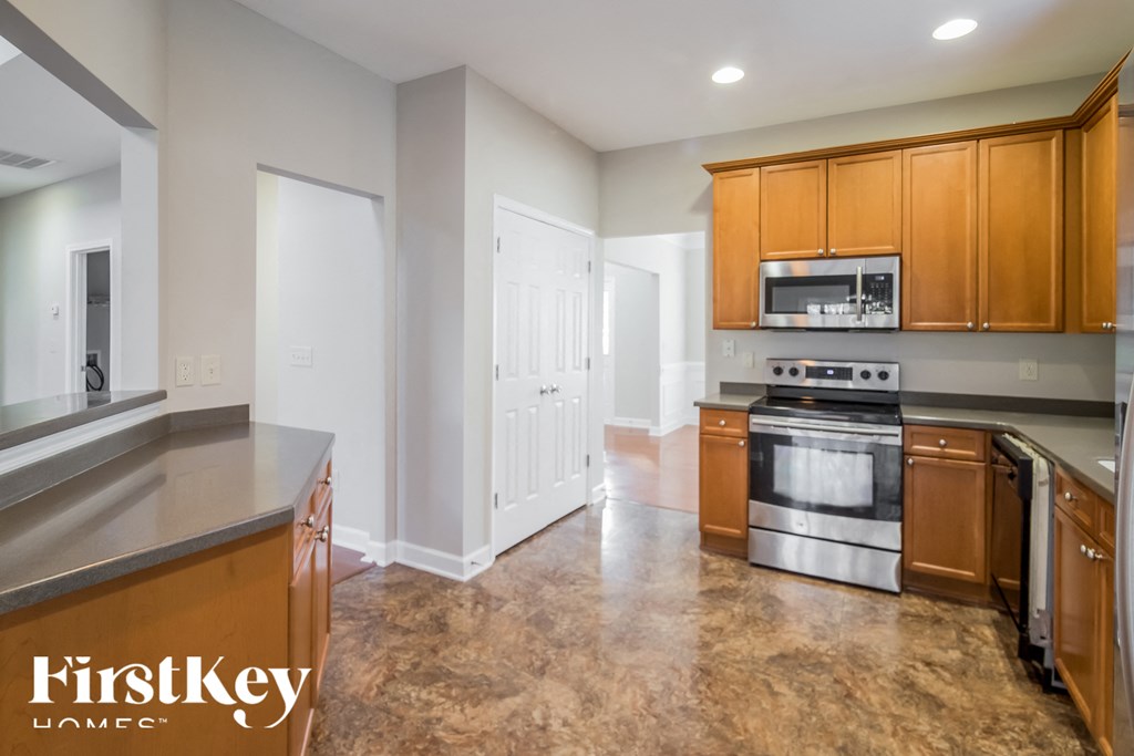 A kitchen with a stove top oven and a microwave above it.