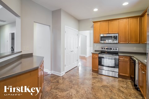 A kitchen with a stove top oven and a microwave above it.