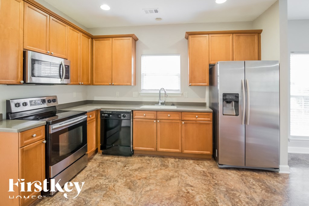 A kitchen with wooden cabinets and a refrigerator.