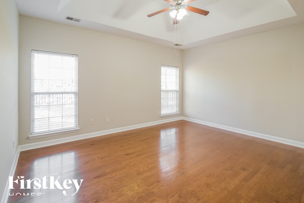 A room with wooden floors and a ceiling fan.