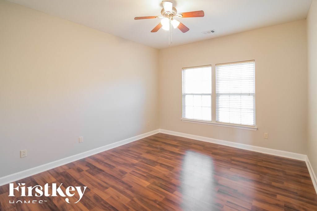 A room with a wooden floor and a ceiling fan.
