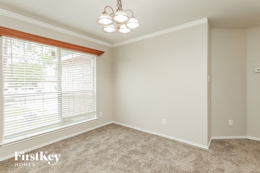 an empty bedroom with a large window and a chandelier