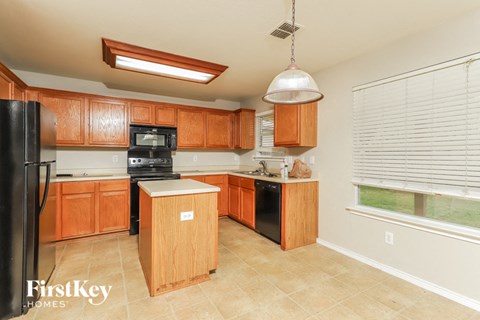 a large kitchen with wooden cabinets and black appliances