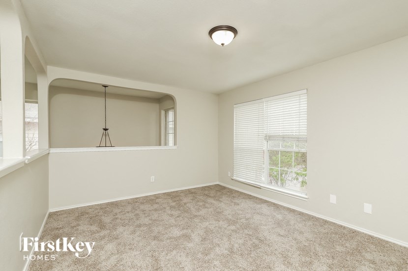 an empty living room with a large window and carpet