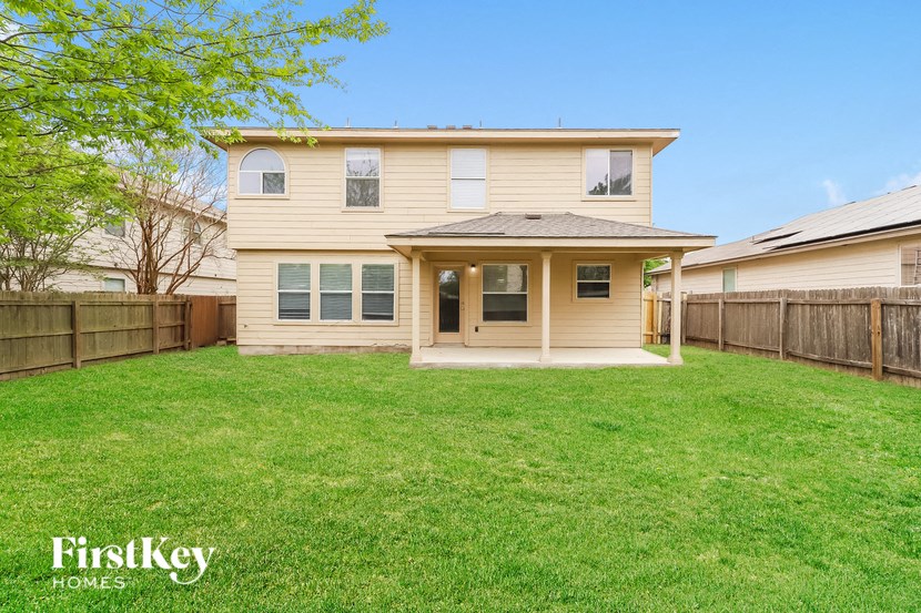 a yellow house with a yard and a wooden fence