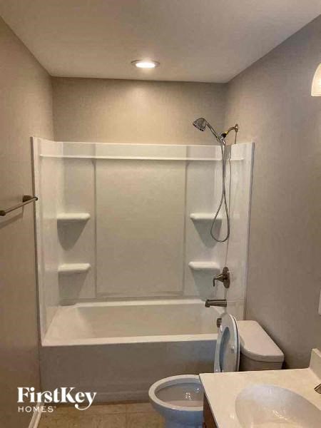 a bathroom with a shower and a toilet and a sink