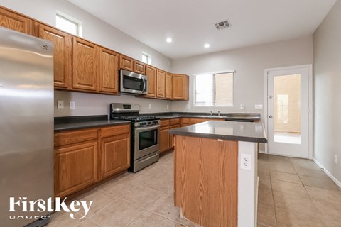 A kitchen with wooden cabinets and a stainless steel refrigerator.