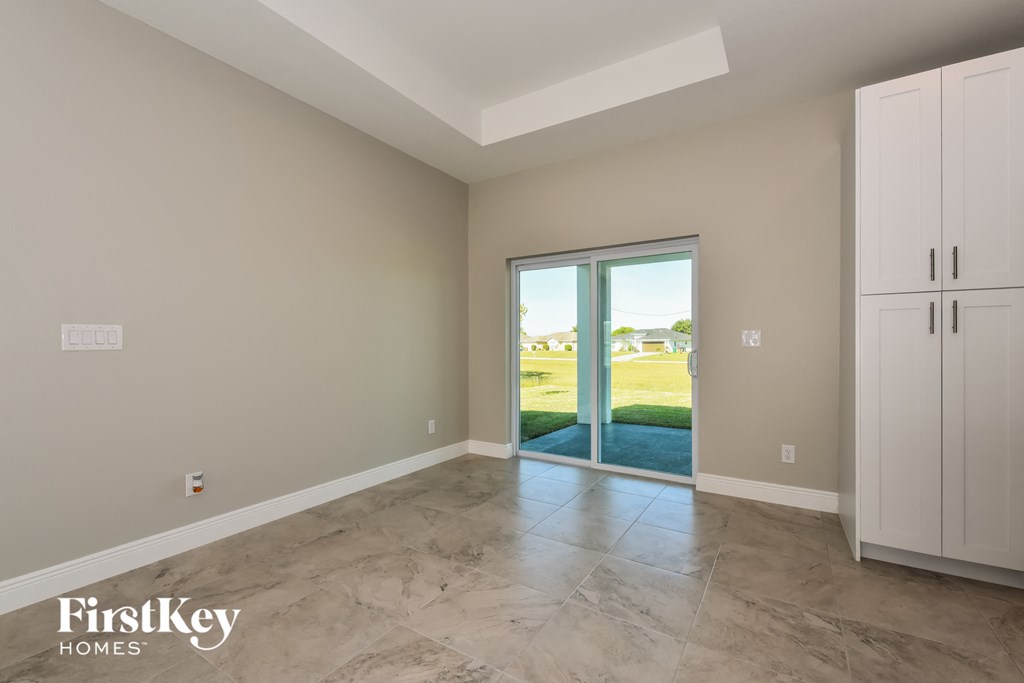 A room with a sliding glass door leading to a backyard.