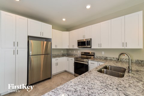 A kitchen with a granite counter top and stainless steel appliances.