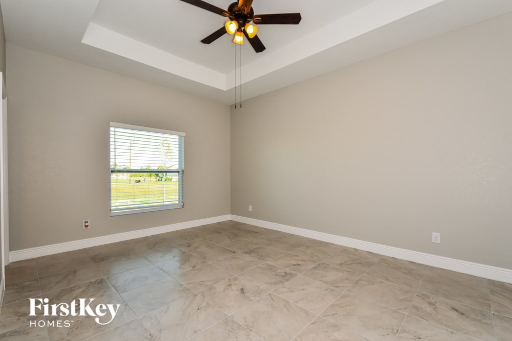 A room with a ceiling fan and a window.