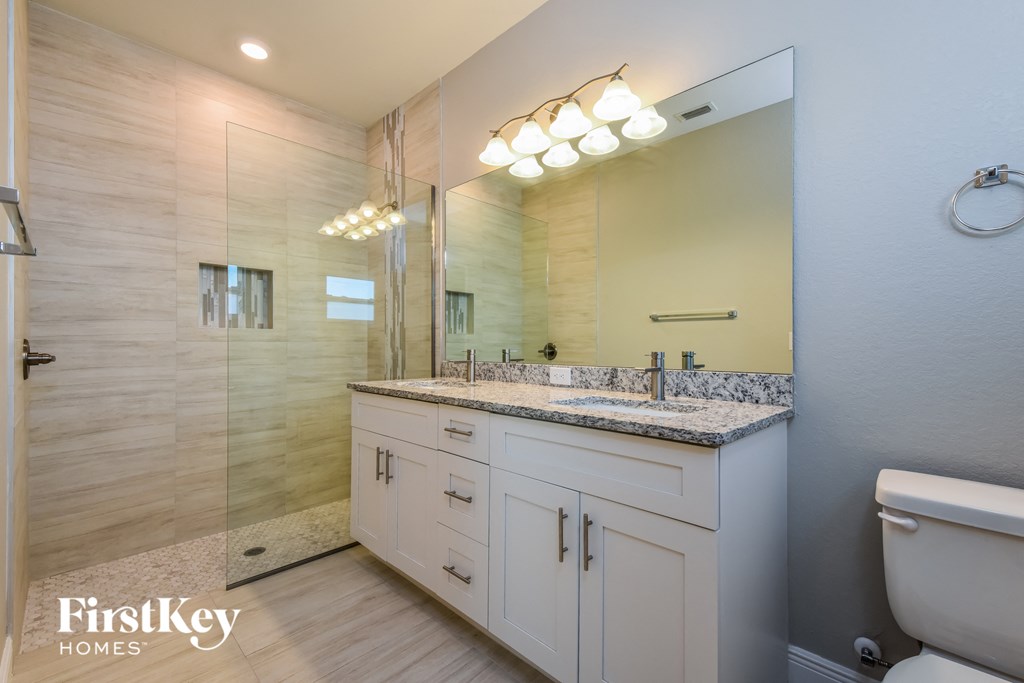 A bathroom with a sink, mirror, and toilet.