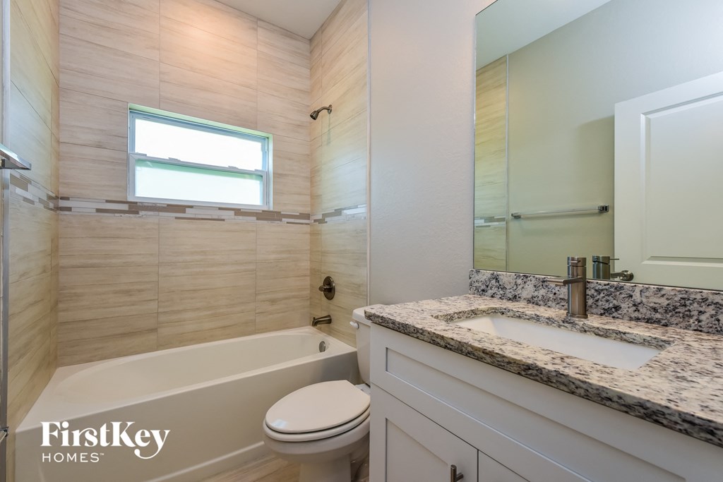A bathroom with a tub, toilet, and sink.