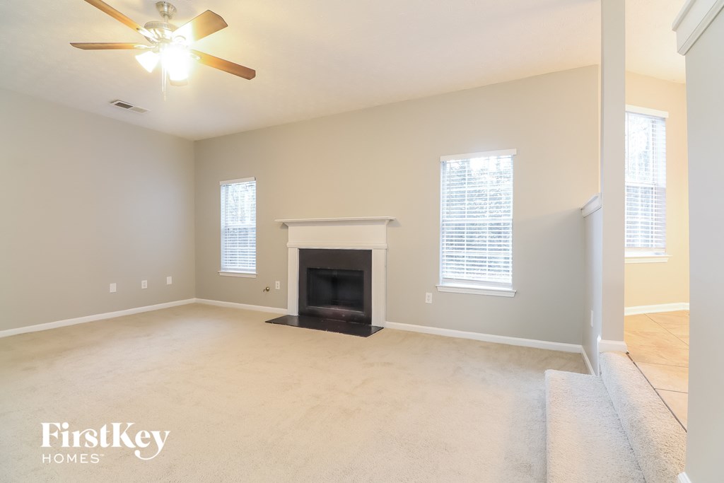a living room with a fireplace and a ceiling fan