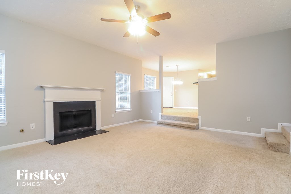 a living room with a fireplace and a ceiling fan