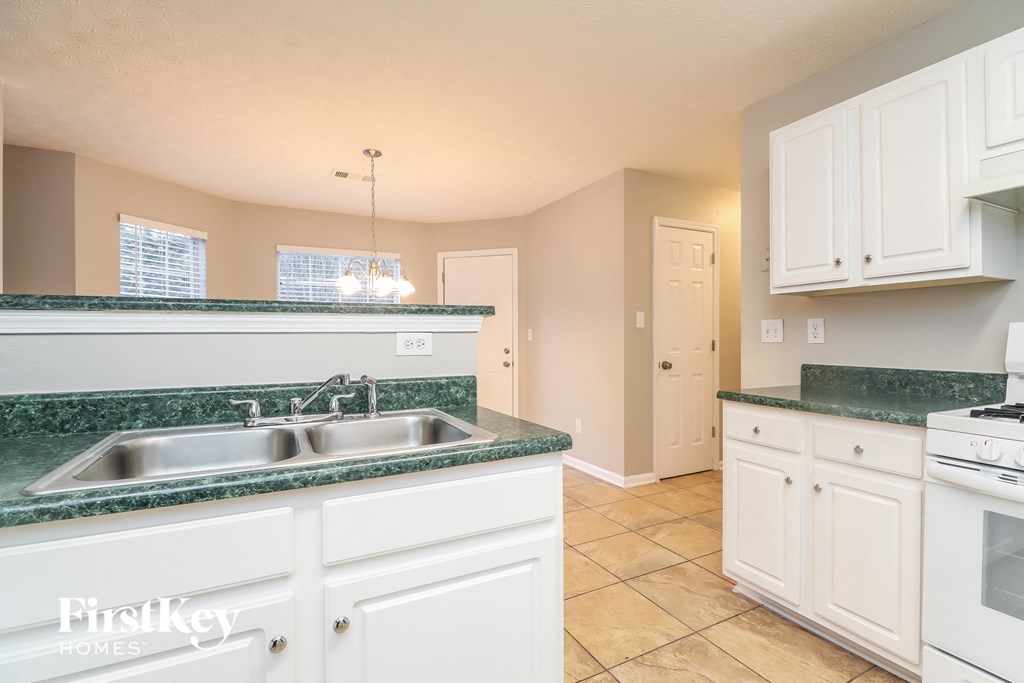 a kitchen with white cabinets and green counter tops