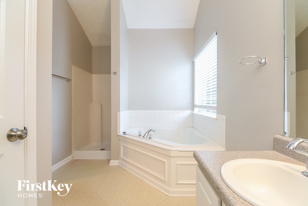 a bathroom with a tub and a sink and a mirror