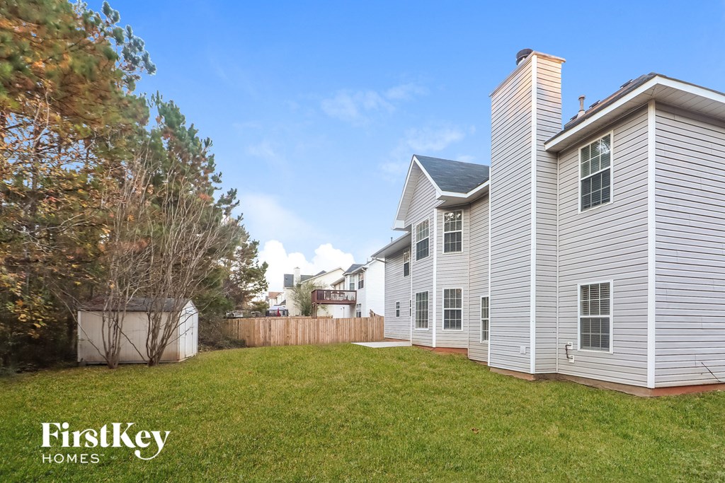the backyard of a house with a yard and a fence
