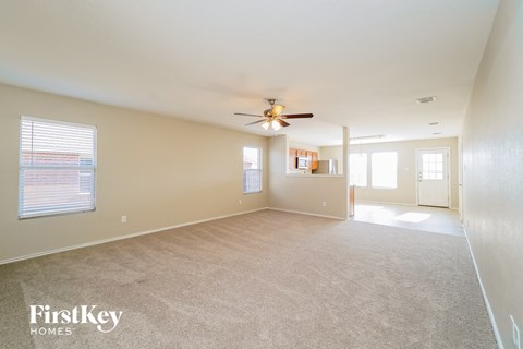 A spacious room with a ceiling fan and carpeted floor.