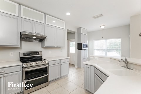 a white kitchen with stainless steel appliances and white cabinets