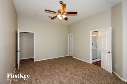 a bedroom with a ceiling fan and a door to a closet