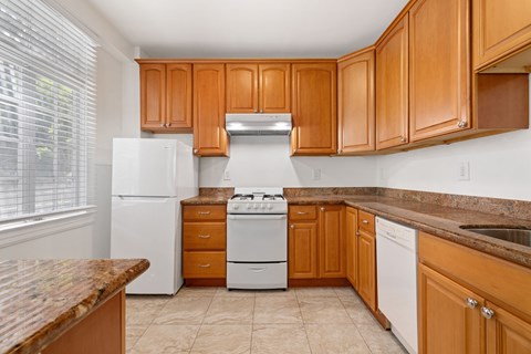 A kitchen with wooden cabinets and a white refrigerator.