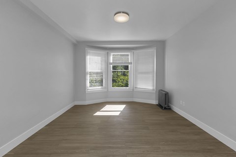 A room with a window and a radiator on the floor.