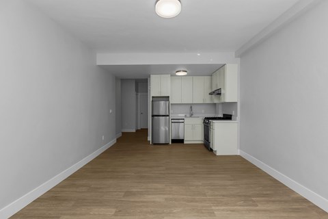 A kitchen with white cabinets and a wooden floor.