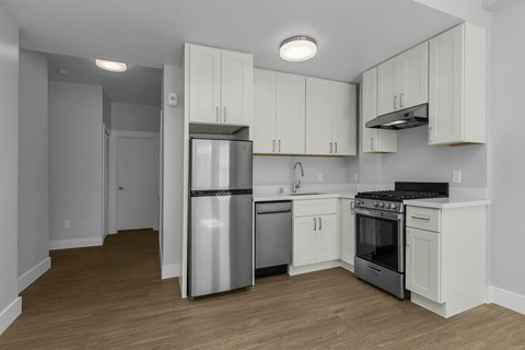 A kitchen with white cabinets and stainless steel appliances.