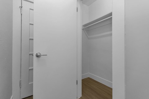 A white door with a silver handle is open to a white interior.
