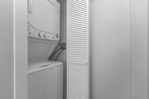 A white oven is installed in a white wall.