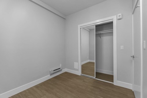 A room with a white wall and a wooden floor.