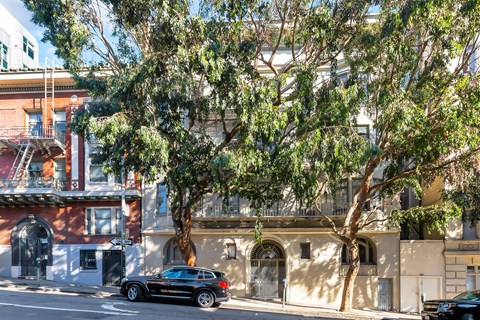 A black car is parked on the side of a street.
