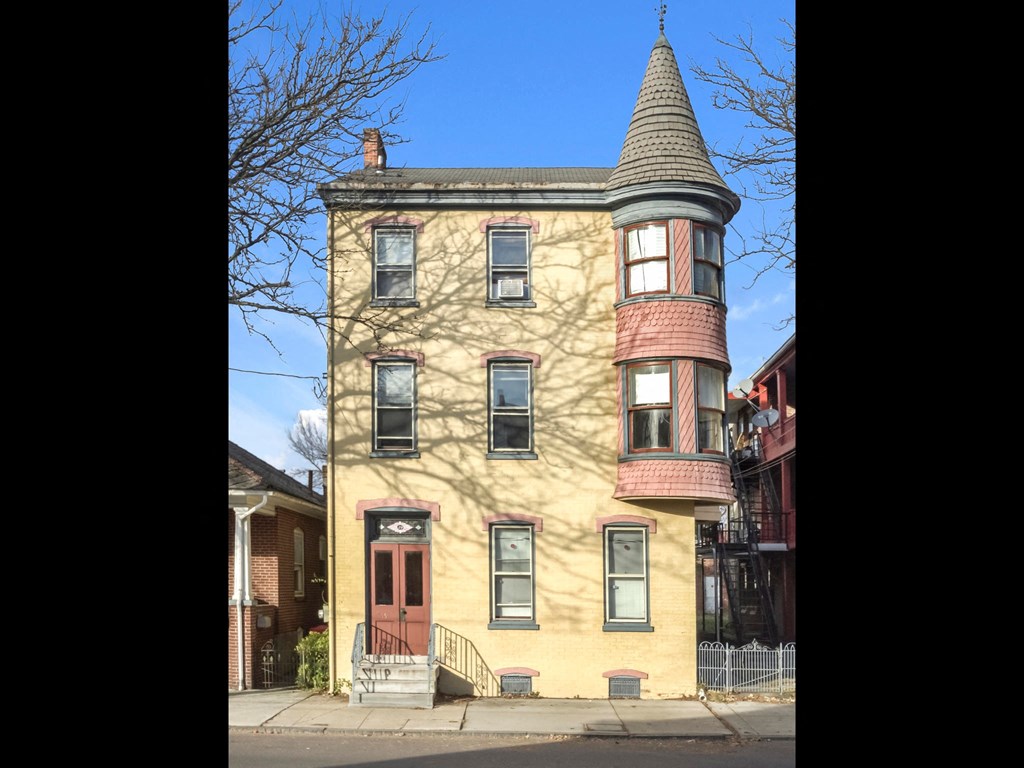 a house with a cone shaped roof on a street
