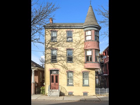 a house with a cone shaped roof on a street