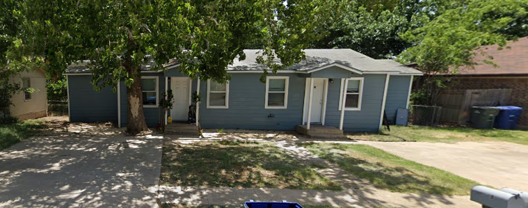 a blue house with a tree in front of it