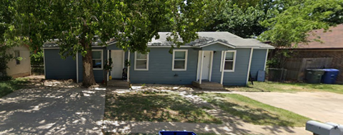 a blue house with a tree in front of it