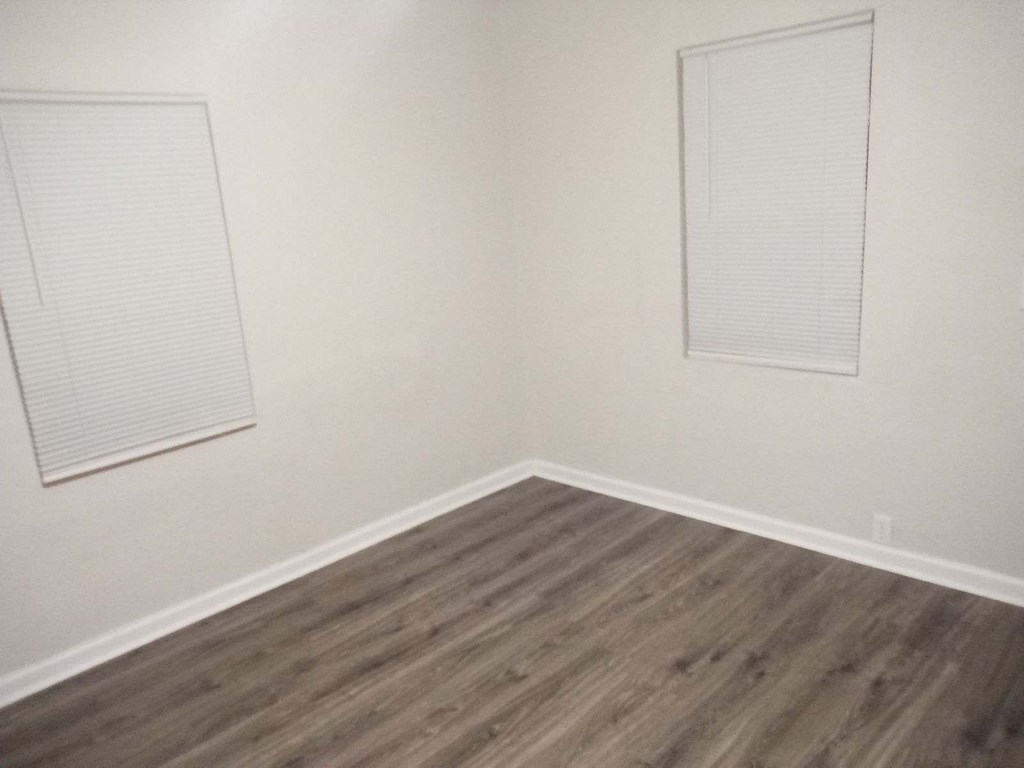 an empty room with white walls and wooden floors