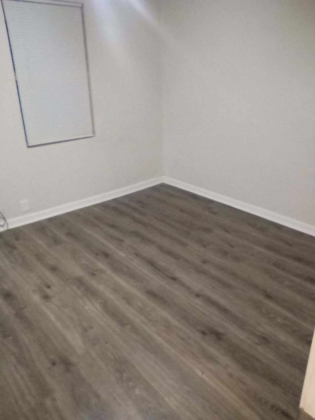 an empty room with wooden floors and white walls