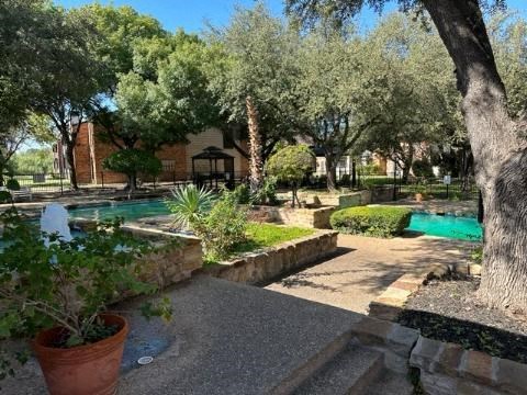 a backyard with a swimming pool and trees