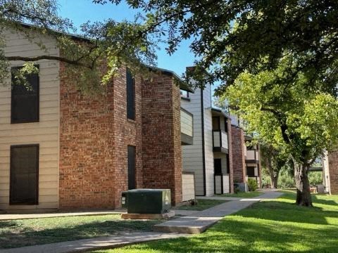 a brick building with trees in front of it