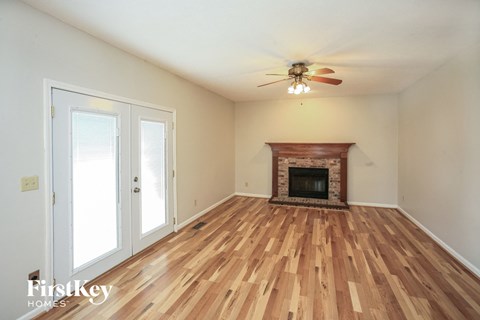 A room with a fireplace and wood flooring.