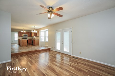 A spacious room with a ceiling fan and wooden flooring.
