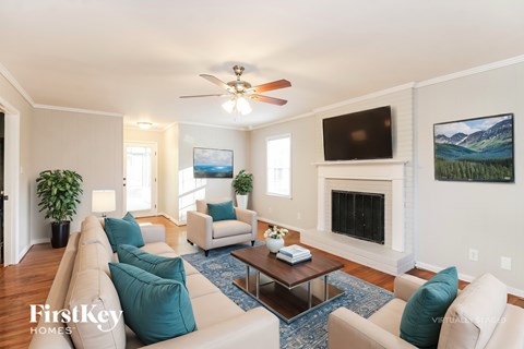 A living room with a fireplace and a television on the wall.