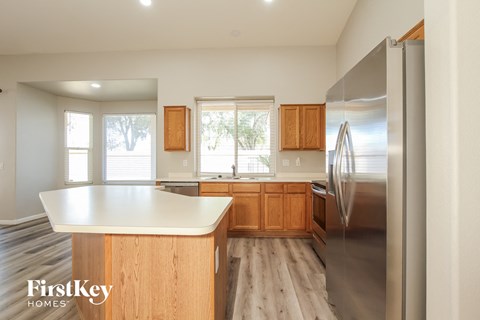 a kitchen with wooden cabinets and stainless steel appliances and a white counter top