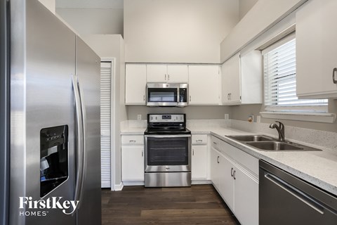a kitchen with white cabinets and stainless steel appliances